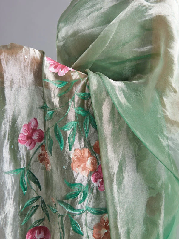 Green ombré on a silver silk tissue saree with hand-painted and embroidered details.