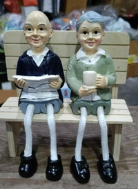 Couple polyresin statues on wooden bench