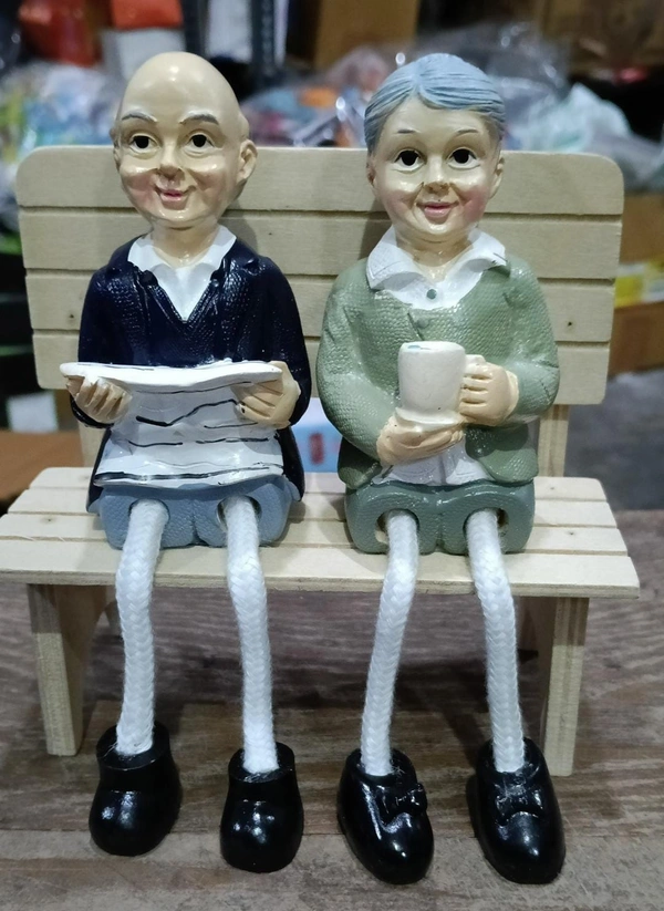 Couple polyresin statues on wooden bench