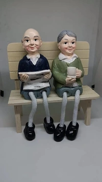 Couple polyresin statues on wooden bench