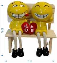 Couple polyresin statues on wooden bench